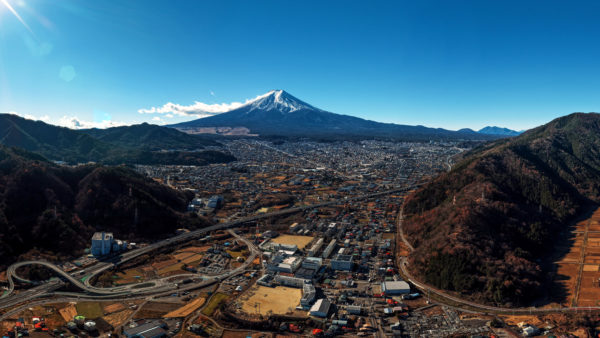 富士山と富士吉田市街地を高高度から俯瞰したパノラマ空撮写真